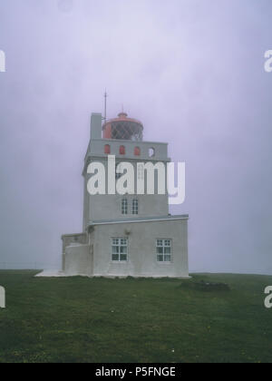 Leuchtturm im Nebel in Island mit roter Spitze gedeckt, Windows Stockfoto