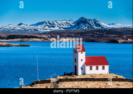 Einsame Kapelle mit markanten roten Dach am Ufer des See Thingvallavatn in kontrastreichen Farben tagsüber, Island april 2018 abgedeckt Stockfoto