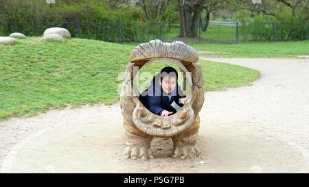 Ein Junge in einem hippo Statue Stockfoto