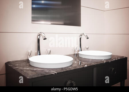 Badezimmer Einrichtung in warmen Beigetönen und mit zwei Waschbecken und Wasserhahn Stockfoto