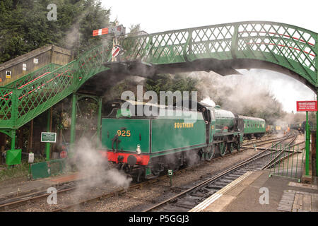 Landsmann Dampfzug vorbei unter einer Fußgängerbrücke am Alresford in Hampshire. Brunnenkresse Museumsbahn weitgehend besetzt von Freiwilligen. Stockfoto