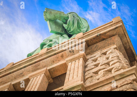 Ungewöhnlicher Blick auf den Blick auf die Freiheitsstatue auf Liberty Island, in der Nähe von Manhattan, wobei der Schwerpunkt auf dem Buch in der linken Hand Stockfoto