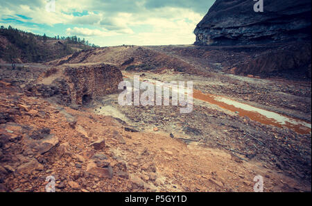 Alte Steinmauer an den Ufern des Roten Flusses (Riotinto) von sauren Gewässern, mit einem niedrigen pH-Wert durch die Mineralien hergestellt, Spanien Stockfoto