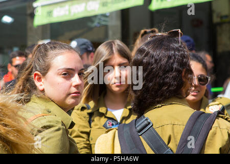 9. Mai 2018 eine junge aus weiblichen Israelischen Armee Wehrpflichtigen schaut weg von ihrer Gruppe wehmütig, wenn sie am Markt Mahane Yehuda Jerusalem entspannen Stockfoto