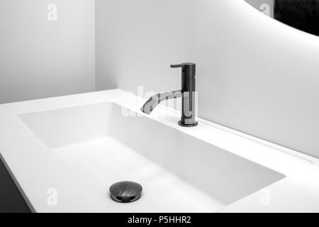 Badezimmer Einrichtung in Weiß mit weißen Waschbecken und schwarz Moderner Techno style Wasserhahn Stockfoto