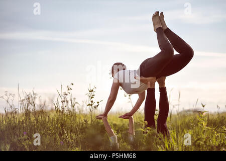 Zwei Frau auf dem Feld zu tun fitness Yoga Übung zusammen. Stockfoto