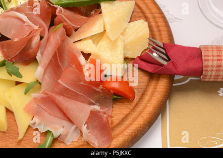 Trocken-cured pork Slices, Tomate und Käse auf Holz Schneidebrett Stockfoto