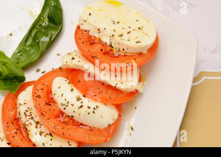 Köstliche Caprese Salat mit reifen Tomaten und Mozzarella mit frischem Basilikum. Italienisches Essen. Stockfoto