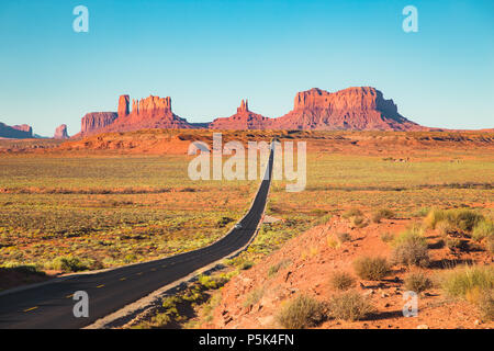 Classic Panorama der historischen U.S. Route 163, die durch die berühmten Monument Valley in wunderschönen goldenen Abendlicht bei Sonnenuntergang im Sommer, USA Stockfoto