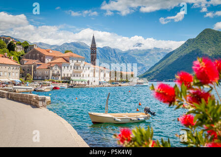 Malerische panorama Blick auf die historische Stadt Perast an der berühmten Bucht von Kotor mit blühenden Blumen an einem schönen sonnigen Tag mit blauen Himmel und Wolken Stockfoto