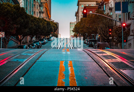 Low Angle Dämmerung Blick auf eine leere Straße mit Seilbahn Tracks, die einen steilen Hügel an der berühmten California Street im Morgengrauen, San Francisco, Kalifornien, USA, Stockfoto