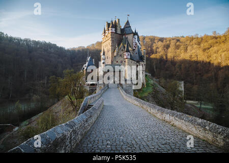 Schönen Blick auf die berühmte Burg Eltz im malerischen golden Morgen bei Sonnenaufgang mit blauem Himmel an einem sonnigen Tag im Herbst mit Retro Vintage Frage neue Stil filt Stockfoto