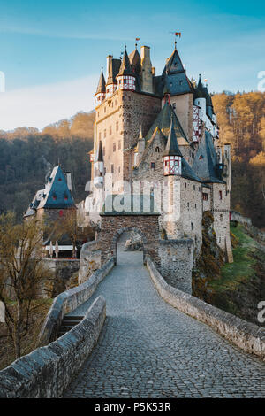 Schönen Blick auf die berühmte Burg Eltz im malerischen golden Morgen bei Sonnenaufgang mit blauem Himmel an einem sonnigen Tag im Herbst mit Retro Vintage Frage neue Stil filt Stockfoto