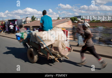 Jungs Ziehen und Schieben eine Karre in Madagaskar Stockfoto