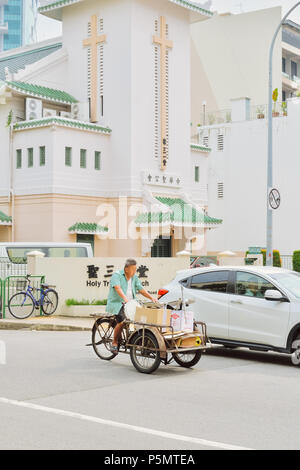 2018 Singapur. Ein Mann reitet ein Fahrrad Warenkorb einige Güter zu transportieren. Vom Erscheinungsbild der Gentleman Materialien transportiert werden können einem Recycling zu verkaufen Stockfoto