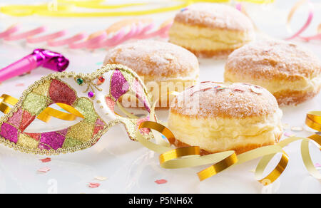 Karneval Puderzucker angehoben Donuts mit Papier Luftschlangen und venezianische Maske. Stockfoto