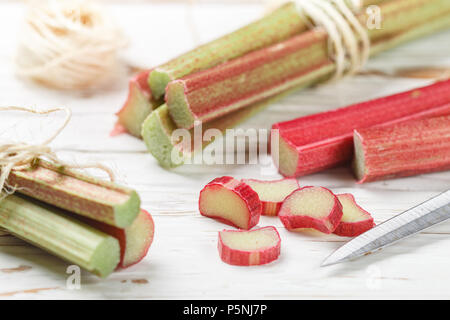 Frische organische Rhabarber auf einem weißen alten Holztisch. Selektiver Fokus, kopieren Raum Stockfoto