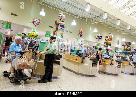 Naples, Florida, Publix Supermarkt, elektrischer Einkaufswagen, eingeschränkter Mobilität, Kassierer, Bagger, Einkaufswagen, lateinamerikanische lateinamerikanische lateinamerikanische ethnische Immim Stockfoto