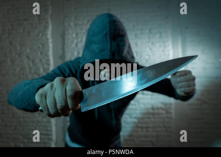 Nahaufnahme einer Hand ein Messer gefährlicher mit Kapuze Mann im Dunkeln in London Messer Kriminalität Konzept. Stockfoto