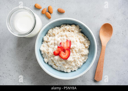 Haferflocken Porridge mit Erdbeeren Ansicht von oben. Brei Hafer in blauer Schüssel. Ansicht von oben gesundes Frühstück Stockfoto