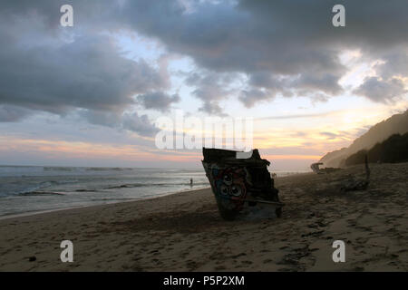 Nyang nyang-Strand und einige kaputte rustikalen Schiffswracks bei bewölkter Sonnenuntergang. In Bali, Juli 2018 berücksichtigt. Stockfoto