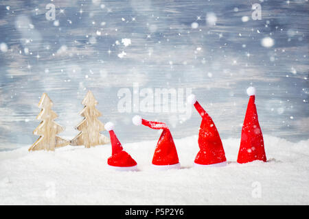 Vier Santa Weihnachten Hüte vor Schnee, Sterne und Bäumen. Stockfoto