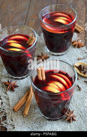 Wein mit Zitronenschale in Gläsern auf hölzernen Hintergrund Glühwein Stockfoto