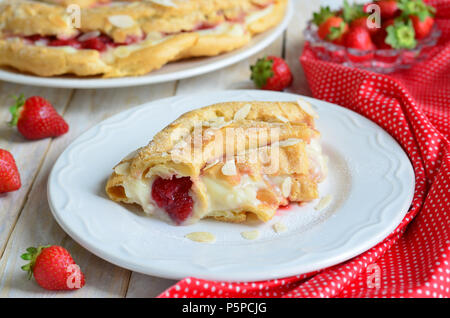 Erdbeertorte mit Vanillepudding und Brandteig auf weißem Hintergrund Stockfoto