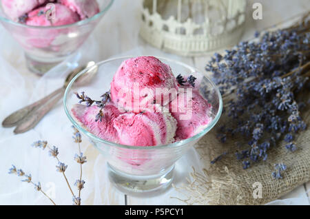 Lavendel und Schwarze Johannisbeere ums Himbeereis auf weißem Hintergrund Stockfoto