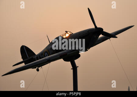 Hawker Hurricane Replik gate guardian North Weald Airfield, ehemaligen RAF Royal Air Force die Schlacht um England Zweiten Weltkrieg Airbase. Dämmerung. Sonnenuntergang Stockfoto