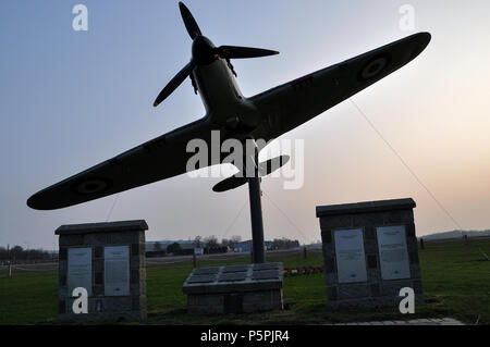 Hawker Hurricane Replik gate guardian North Weald Airfield, ehemaligen RAF Royal Air Force die Schlacht um England Zweiten Weltkrieg Airbase. Dämmerung Stockfoto