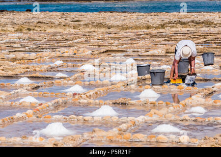 Ernte Meersalz aus dem alten Salinen in Marsalforn, Gozo, Malta. Stockfoto