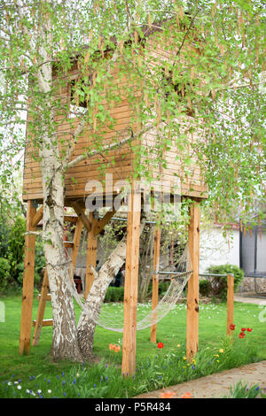 Tree House mit Hängematte unter es im Frühling Stockfoto