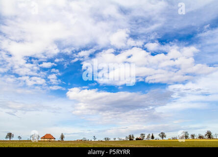 Viele teils bewölkte Himmel und kleine ländliche Landschaft im frühen Frühling in Süddeutschland Stockfoto