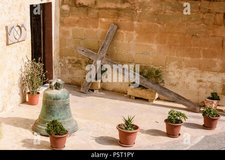 Ein großes Holzkreuz liegt vor einer Wand vor einem Haus in Gozo, Malta Stockfoto