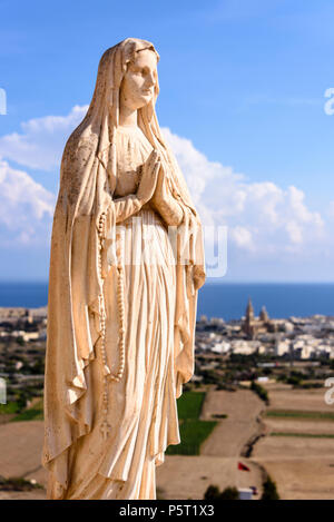 Eine Statue der Jungfrau Maria steht an der Spitze eines Hügels in Gozo, Malta. Stockfoto