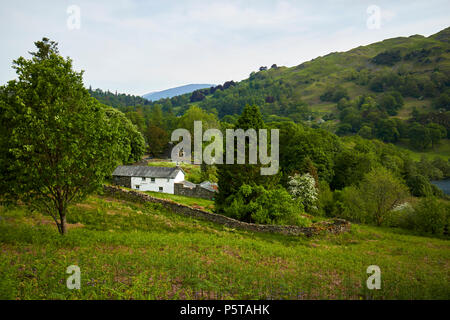 Bauernhaus und die umliegende Landschaft an loughrigg fiel und loughrigg Tarn in der Nähe von Ambleside lake district, Cumbria England Großbritannien Stockfoto