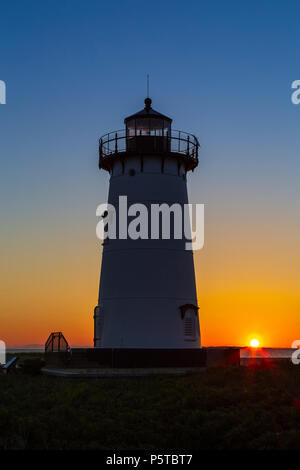 Die aufgehende Sonne bringt Farbe in den Himmel hinter Edgartown Hafen Licht in Chatham, Massachusetts auf Martha's Vineyard. Stockfoto