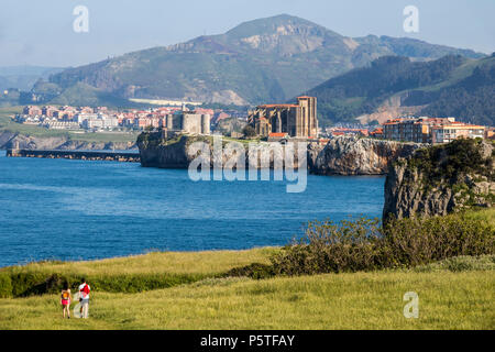 Castro Urdiales, Spanien. Blick auf Santa Maria de la Asunción Kirche und Burg von Santa Ana Leuchtturm aus dem Cementerio de Ballena Stockfoto