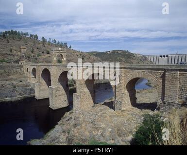 PUENTE DE ALCANTARA CONSTRUIDO ENTRE LOS AÑOS 104 Y 106 - Puente Romano SOBRE EL RIO TAJO CON LA PRESA AL FONDO. Ort: Römische Brücke, Alcantara, CACERES. Stockfoto