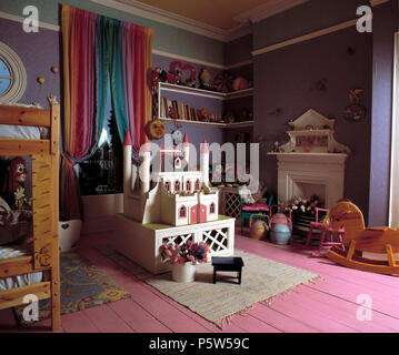 Von Fairytale Doll House in maujve Child's Schlafzimmer mit Rosa lackierten Dielen und Rainbow Vorhänge Stockfoto