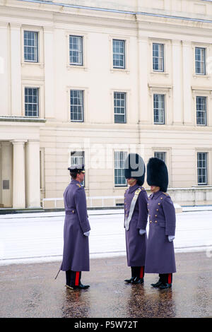 Irish guard Fußsoldaten des Haushalts Division der Queen's Guard am Wachwechsel Zeremonie in London, im Schnee Stockfoto