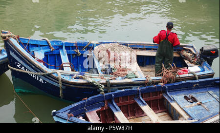 Ein Fischer Vorbereitung Angeln in traditionellem Blau Boot in Essaouira zu gehen Stockfoto