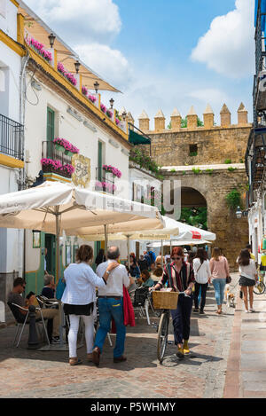 Cordoba Cafe, Ansicht von Menschen zu Fuß hinter einem Cafe Terrasse in einer Straße in der Juderia (alte jüdische) Viertel von Córdoba (Córdoba) Andalusien, Spanien. Stockfoto