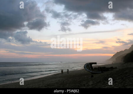 Nyang nyang-Strand und einige kaputte rustikalen Schiffswracks bei bewölkter Sonnenuntergang. In Bali, Juli 2018 berücksichtigt. Stockfoto