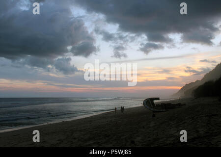 Nyang nyang-Strand und einige kaputte rustikalen Schiffswracks bei bewölkter Sonnenuntergang. In Bali, Juli 2018 berücksichtigt. Stockfoto