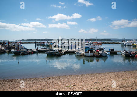 Mit Blick auf das ruhige Wasser und Fisherman's Boote in den Hafen von Poole auf einem hellen, sonnigen Tag mit Brownsea Island in der Ferne liegt. Stockfoto