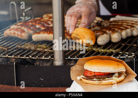 Wurst und Burger auf einer Grillpfanne Stockfoto