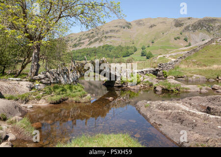 Slater's Bridge ist ein aus dem 17. Jahrhundert Fußgängerzone/Packesel schiefer Brücke über den Fluss Brathay im englischen Lake District Stockfoto