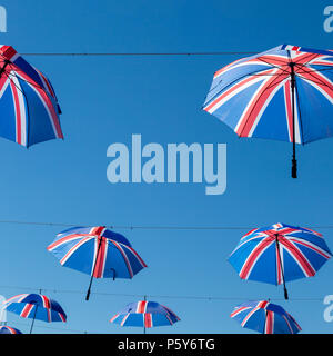 Sonnenschirme unter britischer Flagge gegen einen klaren blauen Himmel Stockfoto